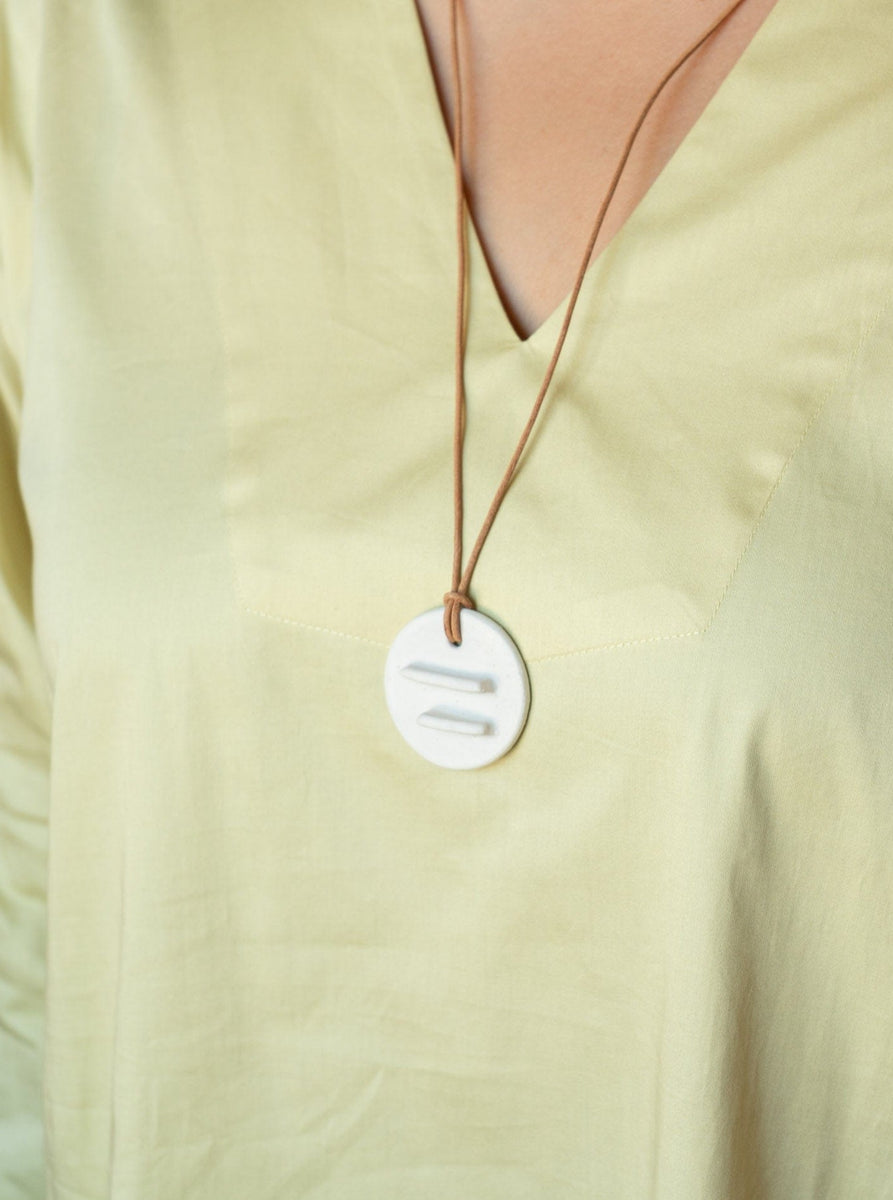 A woman wearing a yellow shirt with a Mini Edena Necklace.
