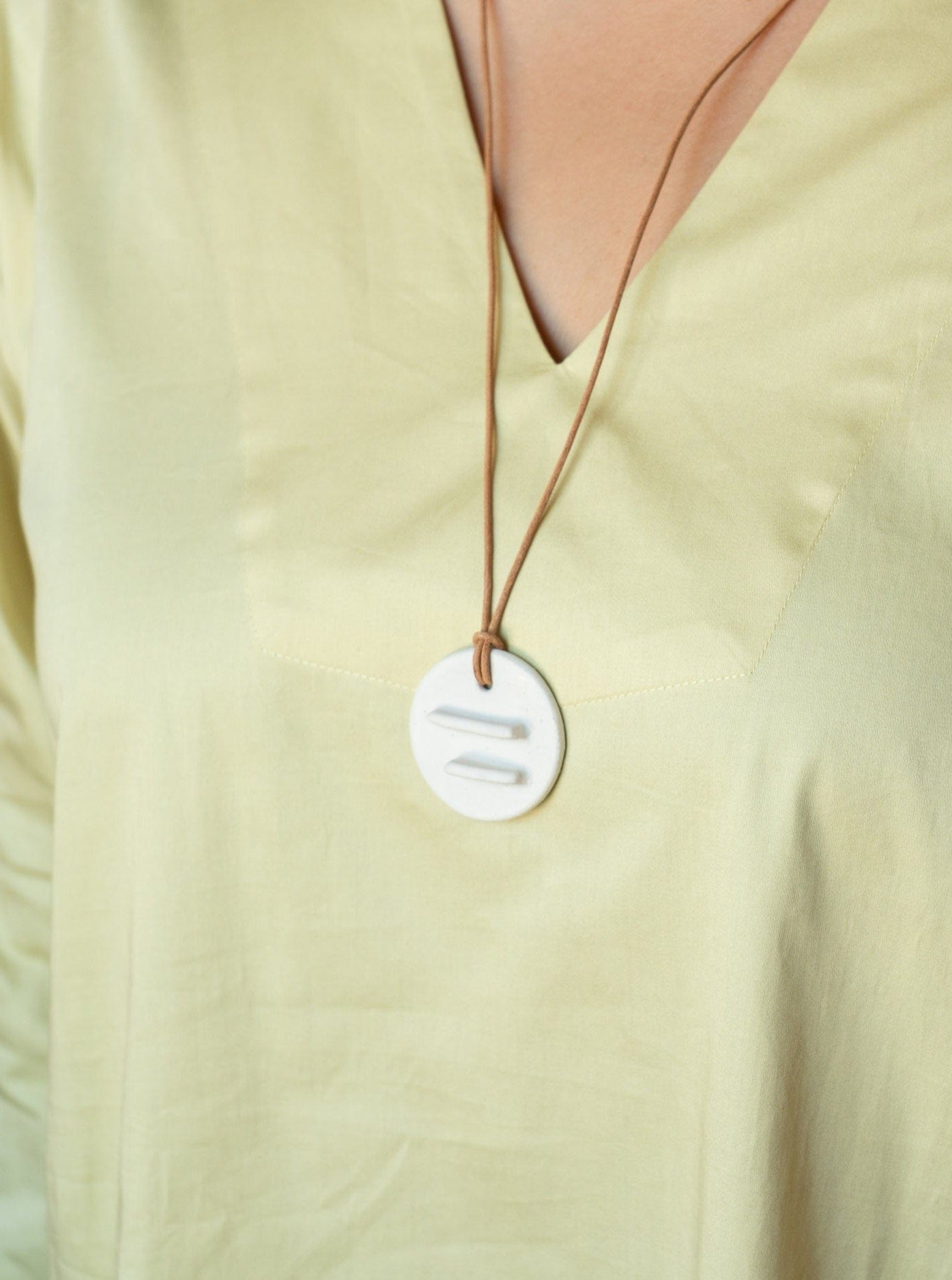A woman wearing a yellow shirt with a Mini Edena Necklace.