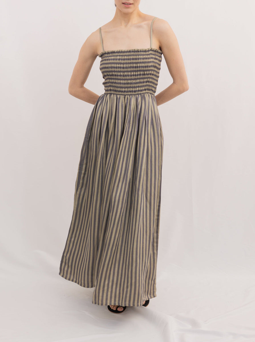 Woman posing in a Spaghetti Strap Maxi Dress - Urban Stripe handmade in India with a smocked bodice against a white background.