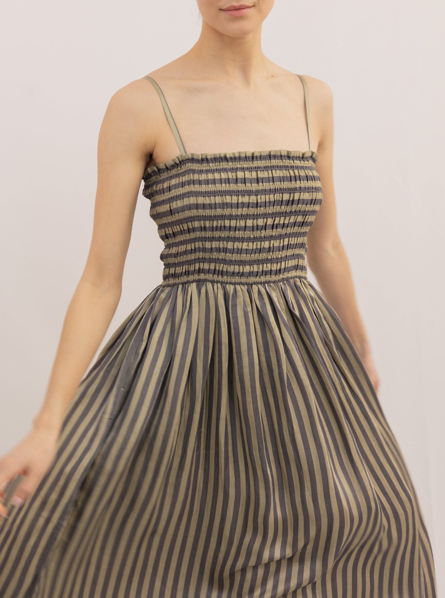 Woman wearing a Spaghetti Strap Maxi Dress - Urban Stripe with a smocked bodice and a pleated skirt.