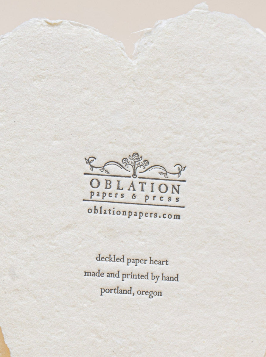 A Leo Tolstoy Card made of cream paper with the word "oblation" letterpress printed on a heart.