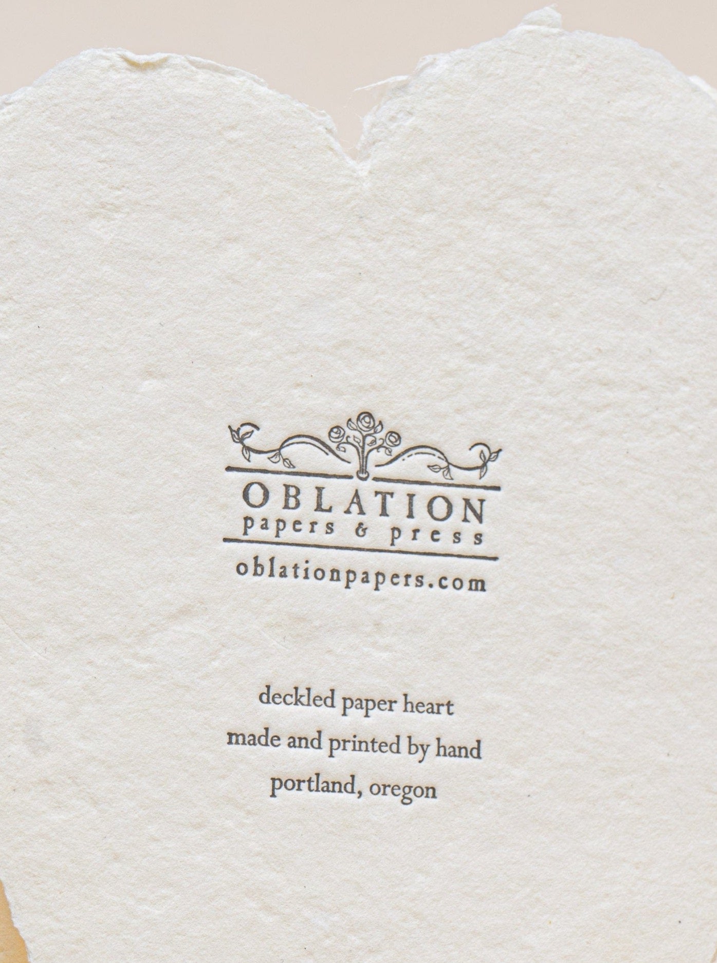 A Leo Tolstoy Card made of cream paper with the word "oblation" letterpress printed on a heart.