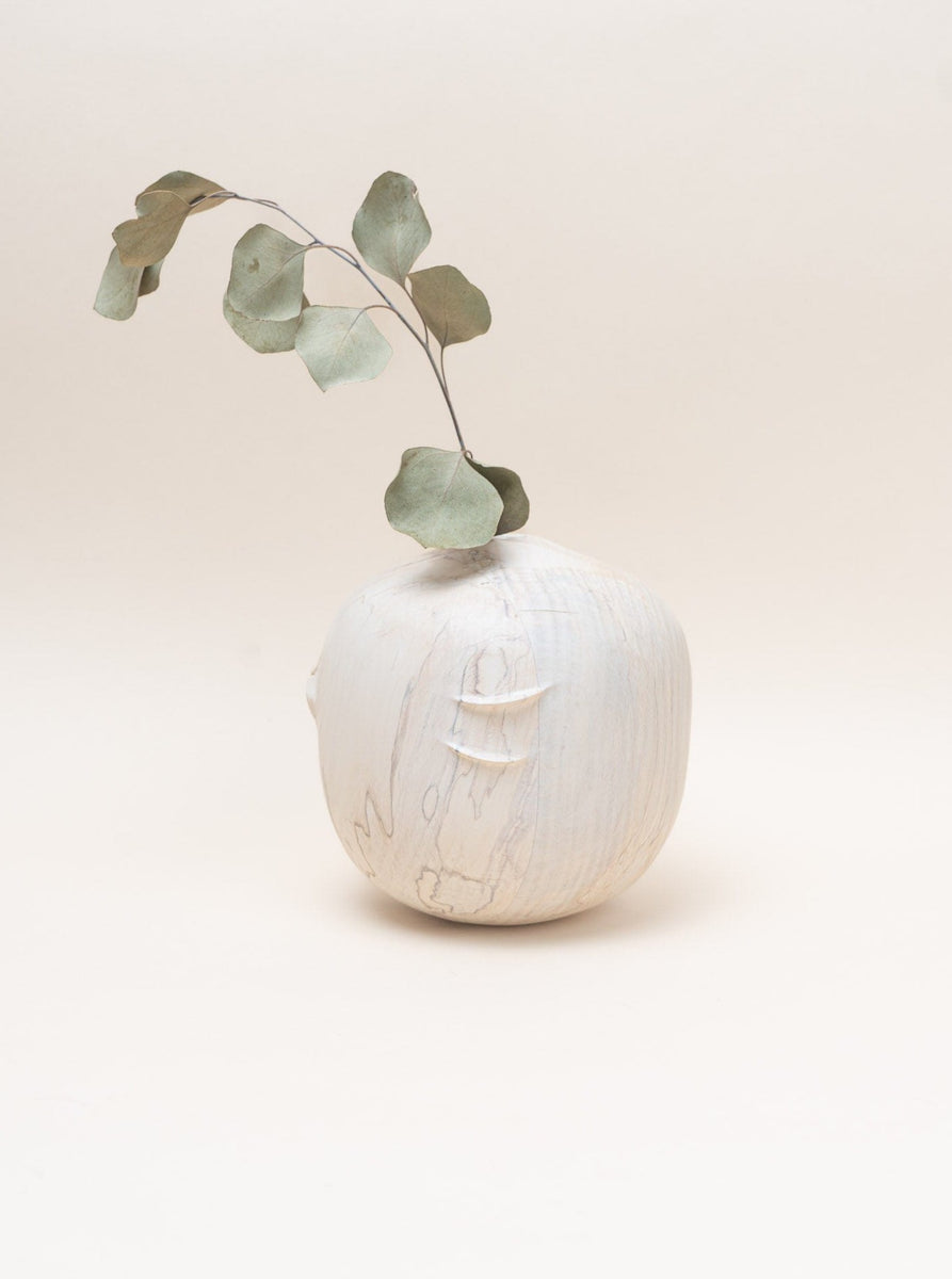 A hand-turned Jume Spalted Wood Vase - Large adorned with eucalyptus leaves, created by a woodcraft designer.