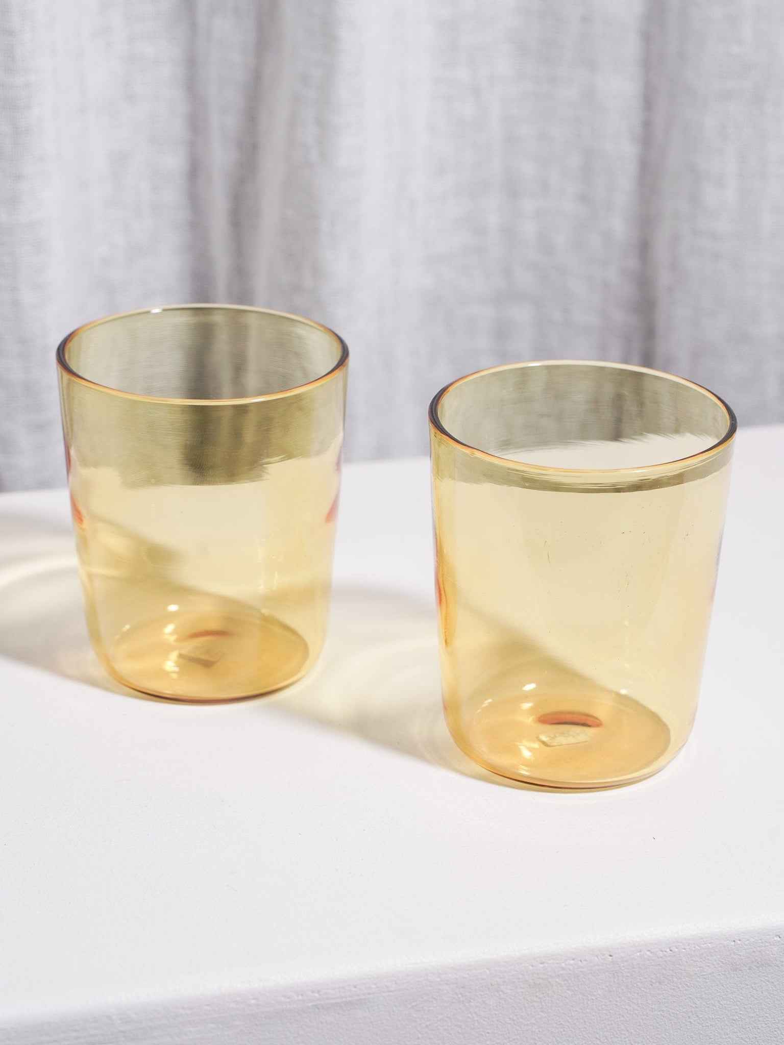 Two handcrafted Tumbler Set - Yellow on the table.